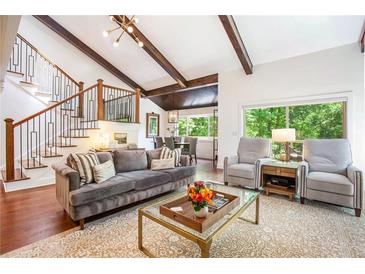 Inviting living room featuring vaulted ceilings, exposed beams, and an adjacent dining area, enhancing the open layout at 2075 Six Branches, Roswell, GA 30076