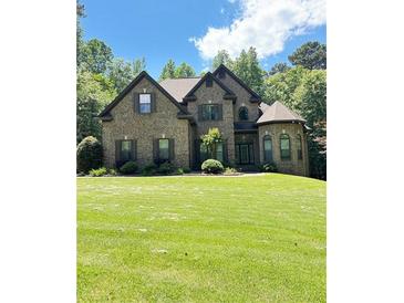 Charming brick home featuring a manicured lawn and lush landscaping at 3400 Suwanee Creek Rd, Suwanee, GA 30024