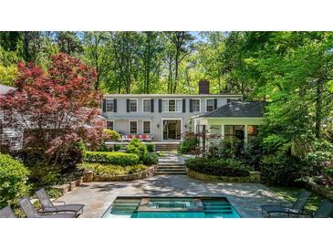 Stunning backyard featuring a pool, flagstone patio, and lush landscaping, perfect for relaxation and entertaining at 2890 Howell Mill Rd, Atlanta, GA 30327