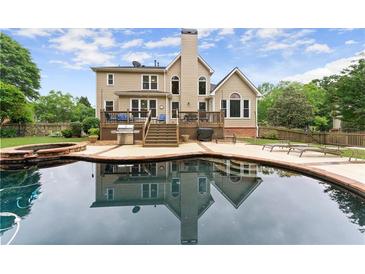 Backyard features a lovely pool with a brick trimmed deck and a cozy porch in a private backyard at 1721 Mulberry Lake Dr, Dacula, GA 30019