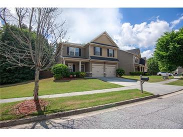 Charming two-story home featuring a well-manicured lawn and a two-car garage, creating an inviting curb appeal at 4271 Haywater Cv, Buford, GA 30519