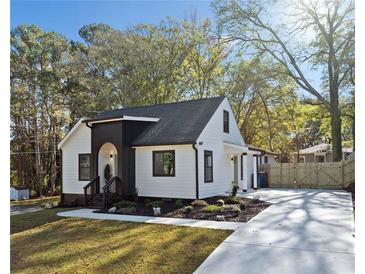 Charming renovated home featuring a modern color scheme, a new driveway and lush landscaping at 2442 Connally Dr, East Point, GA 30344