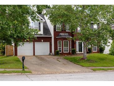 Charming two-story brick home with a well-manicured lawn and a two-car garage at 1185 Charter Club Dr, Lawrenceville, GA 30043