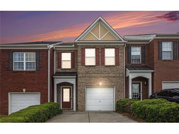 Charming brick townhome with a one-car garage and a well-manicured front yard at 2279 Hawks Bluff Trl, Lawrenceville, GA 30044