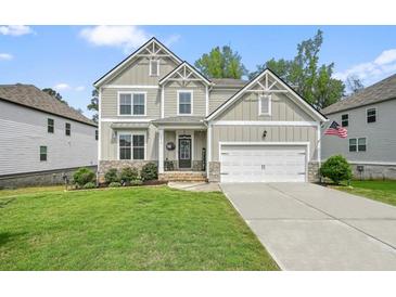 Charming two-story home with well-manicured lawn and inviting front porch, displaying a modern and clean exterior design at 6915 Rambling Vale, Cumming, GA 30028