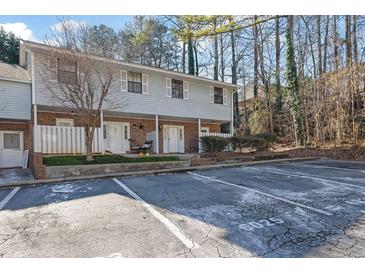 Inviting two-story townhouse with neutral siding, brick accents, and a convenient parking area for residents and visitors at 6027 Wintergreen Rd, Norcross, GA 30093
