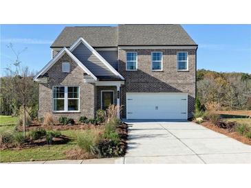 Charming brick two-story home features an attached two-car garage and manicured landscaping at 135 Kingsley Way, Acworth, GA 30102