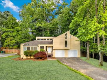 Inviting two-story home featuring a well-manicured lawn, two-car garage, and lush landscaping at 2929 Alberta Dr, Marietta, GA 30062