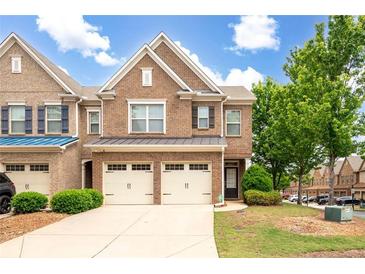 Charming brick townhome with a two-car garage, manicured lawn, and inviting curb appeal at 1957 Brightleaf Way # 59, Marietta, GA 30060
