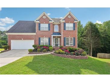 Charming brick two-story home with blue shutters, two-car garage, and lush, landscaped front yard at 3537 Castle View Ct, Suwanee, GA 30024