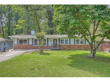 Charming single story home featuring a well manicured lawn, brick accents, and a classic exterior at 2648 Woodacres Ne Rd, Atlanta, GA 30345