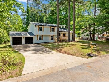 Charming home with a two-car garage, long driveway, and beautiful yard surrounded by mature trees at 4058 Daron Ct, Ellenwood, GA 30294