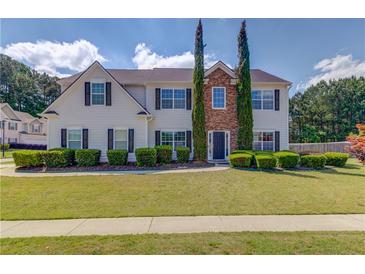 Charming two-story home with well-manicured lawn and mature landscaping at 1043 Lexus Dr, Lawrenceville, GA 30045