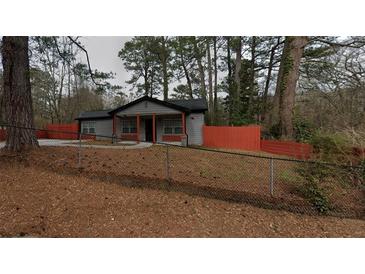 Charming single-story home with gray siding, an orange fence, and a well-maintained lawn at 3479 Thompson Nw Dr, Atlanta, GA 30331