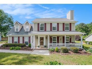 Charming two-story home featuring a welcoming front porch and manicured landscaping in a suburban neighborhood at 1625 Summit View Way, Snellville, GA 30078