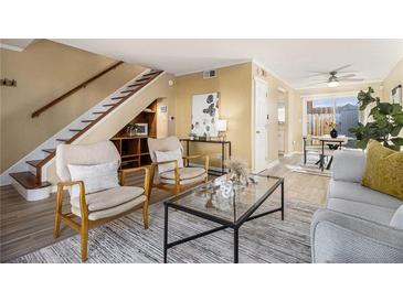 Bright living room featuring hardwood floors, staircase, modern furnishings, and an open floor plan at 136 Peachtree Memorial Nw Dr # Va2, Atlanta, GA 30309