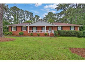 Charming brick home with a well-manicured lawn and a cozy front porch at 2417 Jade Dr, Lawrenceville, GA 30044