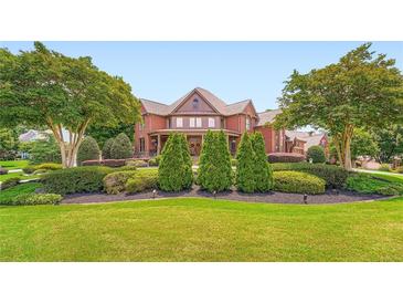 Elegant brick home with manicured lawn and mature trees, offering privacy and curb appeal at 692 Heritage Post Ln, Grayson, GA 30017