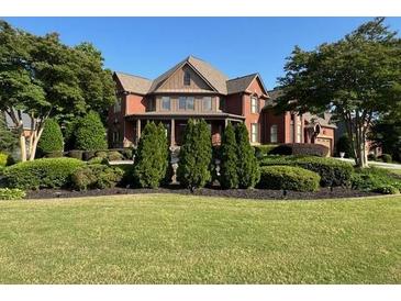 Expansive brick home with manicured landscaping, mature trees, and lush green lawn at 692 Heritage Post Ln, Grayson, GA 30017