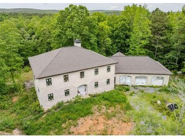 An aerial view of a large two-story house with an attached garage surrounded by trees at 7 Perkins Mountain Rd, Kingston, GA 30145