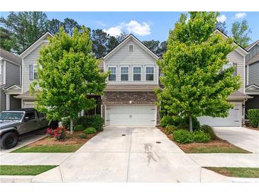 Charming two-story home featuring a two-car garage, brick accents, and a well-manicured front yard with lush trees at 6237 Thorncrest Dr # 10, Tucker, GA 30084