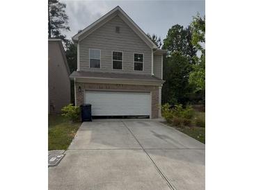 Charming two-story home featuring a brick and siding exterior with an attached two-car garage and a well-maintained driveway at 2285 Crossrail Dr, Atlanta, GA 30349