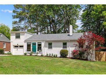 Charming white brick home featuring a green front door and well-maintained lawn and landscaping at 2342 Eastway Rd, Decatur, GA 30033