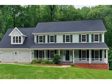 Charming two-story home featuring a welcoming front porch, well-manicured lawn, and attached two-car garage at 2976 Matthew Ln, Lawrenceville, GA 30044