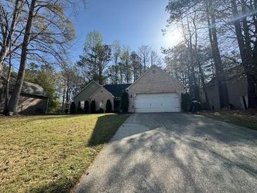 Traditional home featuring brick and siding exterior, well-maintained lawn, and a spacious driveway at 1642 Ashmar Sw Ln, Marietta, GA 30064