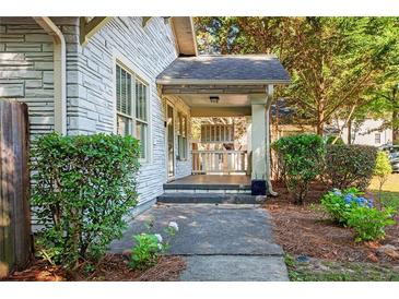 Charming front porch with stone accents and a cozy seating area, surrounded by lush greenery at 1761 Flat Shoals Se Rd, Atlanta, GA 30316