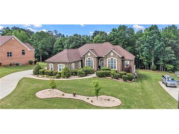 Charming single-story home featuring a well-manicured lawn and lush landscaping at 2628 Hollow Pne, Conyers, GA 30094