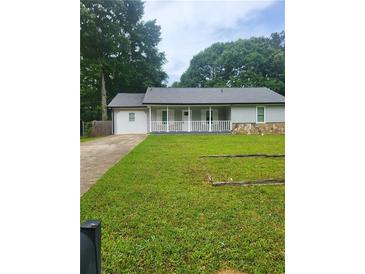 Charming one-story home featuring a white porch, stone accents, and a lush green lawn at 324 Cynthia Ct, Jonesboro, GA 30238