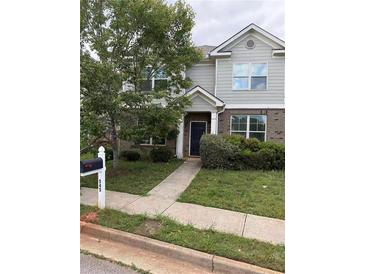 Charming two-story townhouse with brick accents, landscaped yard, and well-maintained walkway at 545 Tulip Ln, Mcdonough, GA 30252
