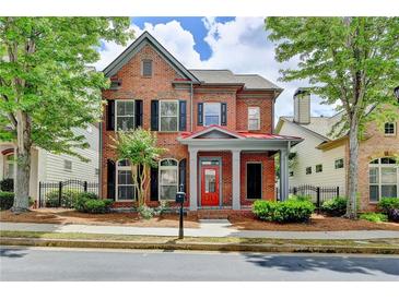 Charming two-story brick home featuring a red door and beautifully landscaped front yard at 375 Causeway Ct, Suwanee, GA 30024