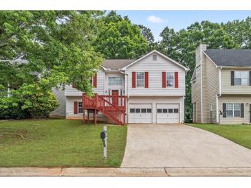 Charming home with red shutters, a two-car garage, mature trees, and a quaint, covered front porch at 2746 Sanibel Se Ln, Smyrna, GA 30082