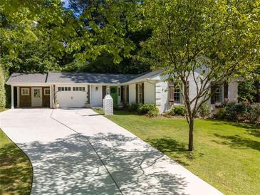 Charming single-story home featuring a white brick facade, dark shutters, manicured lawn and a spacious driveway at 3176 Gablewood Ct, Decatur, GA 30033