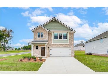 Charming two-story home with neutral brick, landscaped yard, and attached two car garage at 324 Tulip Dr, Covington, GA 30016