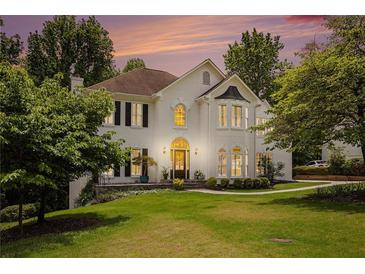 Charming two-story home with a lush green lawn and a beautiful entrance under a colorful sunset sky at 3845 Winters Hill Dr, Atlanta, GA 30360