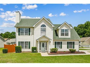 Charming two-story home with a manicured lawn, green roof, and classic architectural details at 5273 High Tide Ct, Atlanta, GA 30349