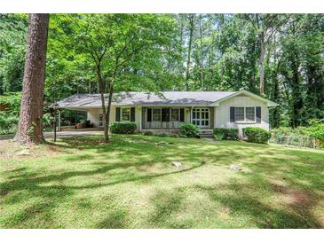 Charming brick home featuring a covered carport and a well-maintained, green front lawn at 1819 King Alfred Sw Dr, Atlanta, GA 30331