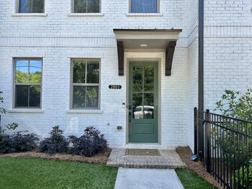 Charming townhouse entrance with a painted white brick facade and a decorative sage-green door at 2893 Elmwood Dr, Smyrna, GA 30080