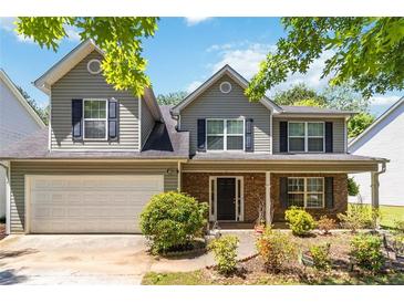 Charming two-story home featuring gray siding, black shutters, brick accents, and a well-maintained front yard at 4065 Waters End Ln, Snellville, GA 30039