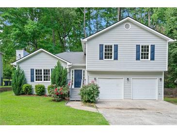 Charming home with a two-car garage, beautiful landscaping and a welcoming entrance at 5590 Princeton Oaks Dr, Sugar Hill, GA 30518