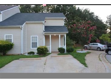 Charming townhouse featuring a well-maintained lawn, a private driveway and a cozy front porch at 6460 Wellington Chase Ct, Lithonia, GA 30058
