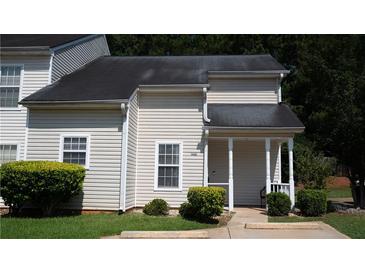 Traditional two-story townhouse with beige siding, dark roof and landscaped front yard at 6460 Wellington Chase Ct, Lithonia, GA 30058