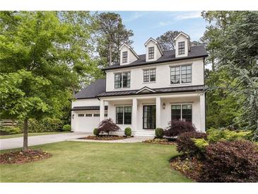 Charming two-story home with manicured lawn, white painted brick, dormer windows, and a welcoming front porch at 304 Meadowbrook Ne Dr, Atlanta, GA 30342