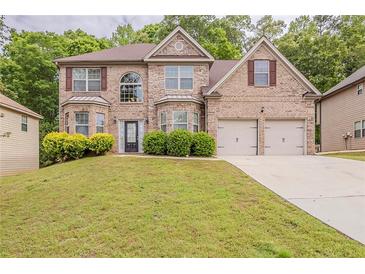 Charming two-story brick home with a well-manicured lawn and attached two-car garage at 3912 Margaux Dr, Atlanta, GA 30349