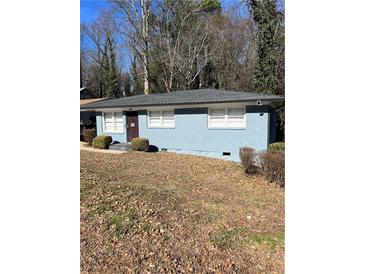 Charming one-story blue brick home with a well-maintained lawn and a cozy front entrance at 3385 Martin Luther King Jr Sw Dr, Atlanta, GA 30331