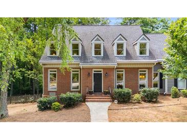 Charming brick front exterior with well-maintained landscaping and black front door at 1061 Polo Club Nw Dr, Marietta, GA 30064