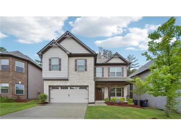 Charming two-story home with a two-car garage, manicured lawn and brick and siding accents at 1867 Castleberry Ln, Buford, GA 30518